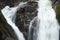 Close up of a waterfall. Dark rocks