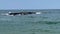 Close up of waves rolling over a jetty of rocks in the ocean