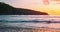 Close-up of waves spreading out over a beach at colorful sunset. Sea crystal bay. Reflection of sun rays on water