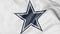 Close-up of waving flag with Dallas Cowboys NFL American football team logo, 3D rendering