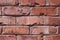 Close-up of weathered red bricks in a house wall
