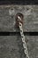 Close-up of weathered wood and a corroded metal chain