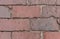 Close up of weathred red brick paved road