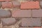 Close up of weathred red brick paved road