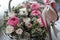 close up of wedding bouquet of roses in wooden basket with ribbon