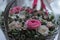 close up of wedding bouquet of roses in wooden basket with ribbon