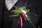 Close up of a wedding boutonniere on the bridegroom suit. The groom chest with green twigs and red berries in buttonhole. Beautifu