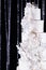 Close up wedding cake decorated with white orchids. Wedding cake at the dark brilliant background