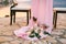 Close-up of a wedding dinner table at reception. Many burning candles stand at the foot of the table on a red silk