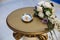 Close-up of the wedding rings of the newlyweds lie on a plate, the table is decorated with flowers, preparation for the