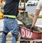 Close up of Wet cement off loaded by construction workers using a shovel from a cement truck chute into a wheelbarrow