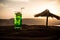 Close up wet glass of green cold mint drink, colorful orange sunset background on the terrace. Cooling summer drink. Summer fresh