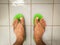 Close up of wet leg wearing a flip flop called `selipar jamban` or `selipar jepun` in the toilet.