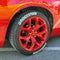 A close-up of the wheel of a red Dodge Challenger car