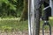 Close-up on the wheel of a wheelchair, from the front, in the middle of nature