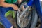 A close-up of the wheels of a motorbike is being removed by a mechanic to recap and change tires due to leaks