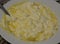 close-up: whisked eggs mixed with sour cream by using a spoon in a white plate