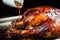 close-up of white bbq sauce glazing over a cooked alabama chicken