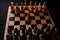 Close up of white and black chess pieces on board. Selective focus on first move of white pawn on chessboard. Concept of