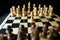 Close up of white and black chess pieces on board. Selective focus on first move of white pawn on chessboard. Concept of