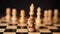 Close up of white and black wooden chess pieces on board. Selective focus on confrontation of black pawn opposite white