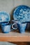 Close-up white and blue ceramic cups and dishes on shelves of pottery store