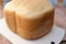 Close-up of white bread on a wooden board freshly baked in an electric bread maker. Homemade baking