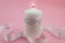 Close up of white candle lit isolated on pink background