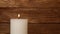 Close up white candle trembling flame over wood