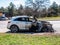 Close-up of a white car on a burnt-out car on the side of the road