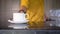 Close up of white coffee cup placed on table by waiter in yellow shirt