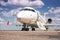 Close-up white corporate business jet with a lowered gangway door on the airport apron