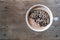 Close-up of white cup with coffee cappuccino on an old brown wooden table, foam in form of silhouette of human brain, concept of