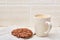 Close-up white cup of coffee with chocolate cookies on white background, top view, shallow depth of field, front focus.