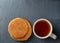 Close-up white cup of coffee with some waffles on dark background, top view