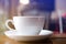Close up white cup with soft steaming hot coffee on table