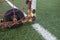 Close up of white goalie cage, rubber wheel,artificial Green lawn soccer European football astroturf with white field markings and