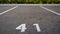 Close-up of a white paint number marking in a parking lot. Empty parking lot, Parking lot with white mark, Open parking in public