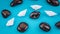 Close up of white paper boats in sigle file between abstract rock stones on blue background