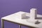 Close up of white paper carton boxes on table isolated over lilac background, three blank cases on desk, studio shot of shells,