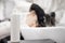 Close-up white plastic bottle for shampoo, background woman washes head in beauty salon. Concept scalp care for baldness