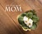 Close up of white primrose plant on a Pine wood table top as rustic background with a mothers day greeting