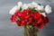 Close-up of a white and red poppies anemones in vase. Many flowers - gray background. winter flower