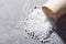 Close-up of white rock salt spilling from wicker container on table with blank space