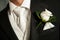 Close up of a white rose corsage on a Groom