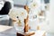 Close up White rose flowers in small transparent glass hanging vases on wooden stand on the coffee table with sunny home