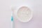 Close-up white tooth powder in an open jar and toothbrush with blue pen on white background. Home Whitening and Hygiene