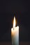 Close up of white wax lit candle flame and wick on black background. candle lights macro. closeup of burning candle isolated on