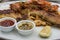 Close up of whole grain mustard seed and chilli sauces with seafood