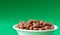 Close-up, whole grain pasta in a white cup on a green background